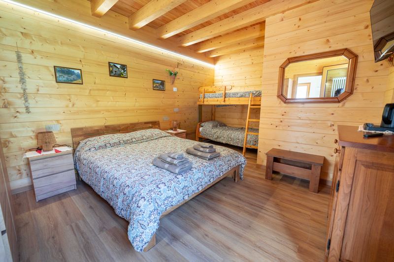 Camera Curt de Gat: letto matrimoniale e, nella nicchia accanto, il letto a castello; pareti e soffitto in legno
