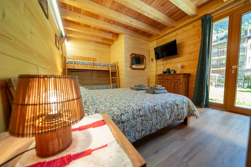 Camera Curt de Gat: lampada sul comodino, letto a castello e portafinestra aperta verso l’esterno