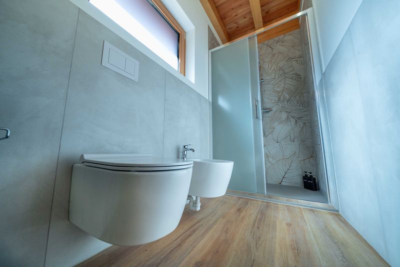 Bagno di Curt de Gat: wc, bidet e doccia con la carta da parati a foglie